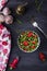 Homemade fresh salad with arugula, strawberries, garlic and cheese roquefort on a dark wooden background. Low key. Top