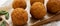 Homemade fried Arancini with basil on a rustic wooden board, low angle view. Italian rice balls. Close-up