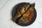 Homemade fried goldfish on a black plate on a wooden table