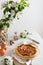 Homemade Galette Pie with Apples and cinnamon on white table with blossom branches. Side view, copy space. Bakery banner. Cookbook