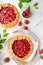 Homemade galettes with strawberries on white marble background