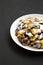 Homemade german Kaiserschmarrn pancake on a white plate on a black surface, side view. Copy space