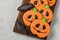 Homemade ginger cookies in the shape of pumpkins and bats on Halloween. On the lighter concrete background. Top view