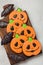 Homemade ginger cookies in the shape of pumpkins and bats on Halloween. On the lighter concrete background. Top view