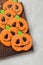 Homemade ginger cookies in the shape of pumpkins for Halloween. On the lighter concrete background. Top view