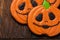 Homemade ginger cookies in the shape of pumpkins for Halloween. On the wooden background. Top view