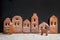 Homemade gingerbread town standing in row with Christmas tree and deer sprinkled with powdered sugar on black background