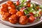 Homemade glazed fried chicken meatballs with fresh salad close-up. horizontal