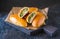 Homemade golden patties with green onion and egg on a black wooden board on a dark concrete background. Unsweetened pastries