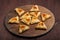 Homemade gomentashi cookies for the Jewish holiday of Purim on a chalkboard are laid out in the form of magen David on