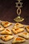 Homemade gomentashi cookies for the Jewish holiday of Purim on a linen tablecloth next to the menorah.