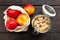 Homemade granola in glass jar and apples in reusable fabric bag on dark wooden table with texture. Healthy breakfast concept and