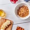 Homemade granola in a plate, banana and various berries on a white wooden table with copy space. Breakfast. Top view