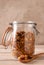 Homemade granola in a storage jar with teh lid open a spoonful in the foreground