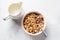 Homemade granola in white bowl, gray background, top view. Muesli bowl for healthy breakfast