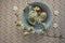 Homemade handmade painted Easter eggs in blue bowl on spotted tablecloth decorated with blackthorn sloe white flowering branch