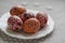 Homemade handmade painted Easter eggs on white plate dish on tablecloth with white petal flowers, Eastertime decoration