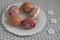 Homemade handmade painted Easter eggs on white plate dish on tablecloth with white petal flowers, Eastertime decoration