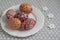 Homemade handmade painted Easter eggs on white plate dish on tablecloth with white petal flowers, Eastertime decoration