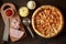 Homemade hawaiian pizza with pineapple, ham, cheese and tomato sauce on wooden background.