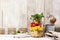 Homemade healthy layer salad in mason jar on a wooden background