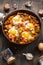 Homemade Hearty Breakfast Skillet with Eggs Potatoes and minced meat on wooden table