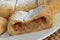 Homemade home-made apple strudel with icing sugar from puff pastry paste full filled pieces of apple with cinnamon on white