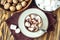 Homemade Hot Chocolate or Cocoa in White Mug with Marshmallows and walnuts on wooden background. Top view.