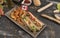 Homemade hot dog with white sausages with various condiments and Canadian flag viewed from above on gray wooden board