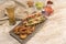 Homemade hot dog on white wooden board with various condiments top view with Canada flag