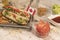 Homemade hot dog on white wooden board with various condiments top view with Canada flag