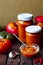 Homemade hot tomato sauce adjika in jars - Tomatoes, chilli pepper, garlic, herbs on wooden table.