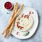 Homemade hummus with pomegranate, thyme, olive oil and pine nuts with grissini bread sticks. Middle Eastern traditional cuisine