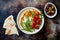 Homemade hummus with roasted cherry tomatoes and olives. Middle Eastern traditional and authentic arab cuisine.