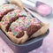 Homemade ice cream sandwich with chocolate chip cookie, watermelon ice cream,  covered with colorful sprinkles, square format