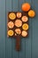 Homemade imperfect cookies and orange slices on dark oak board t