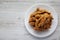 Homemade Italian Cantuccini with Chocolate on a White Plate on a white wooden surface, top view. Crispy Chocolate Cookies. Flat