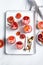 Homemade Italian Granita Dessert with blood orange, elderflower, rose wine  in serving glasses on a white metal tray on a white
