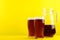Homemade kvass in glasses and jug on yellow background. Space for text