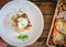 Homemade lasagna with sour cream and fresh chives on wooden background, top view, copy space