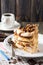 Homemade layered pastry cake and meringue, walnuts, dark chocolate on old wooden background. Selective focus