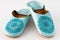 Homemade leather slippers on white background. Pair of blue slipper handmade