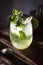 Homemade lemonade with fresh mint leaves at sunset. Moody photography of drink.