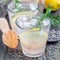 Homemade lemonade with lavender, fresh lemons and rosemary on wooden background, square format