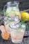 Homemade lemonade with lavender, fresh lemons and rosemary on wooden table, vertical