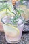 Homemade lemonade with lavender, fresh lemons and rosemary on wooden table, vertical, closeup