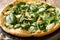 Homemade low-calorie pizza with fresh spinach, garlic and cheese close-up. horizontal