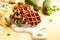 Homemade low carb zucchini waffles on white wooden board on yellow background. Concept of keto diet food