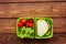 Homemade lunch with cherry, grape and sandwich in green lunchbox top view mockup