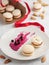 Homemade macarons with currant filling on a gray plate. Selective focus on cookies. Almonds, berries of blackcurrant and filling